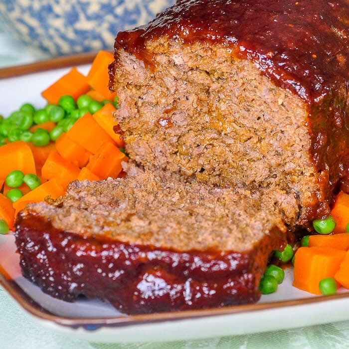 Old Fashioned Meatloaf with sweet onion glaze close up image of cut slice on serving platter.