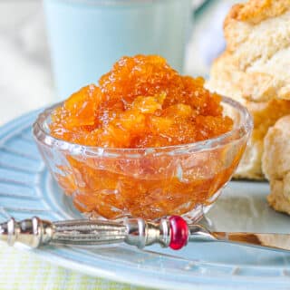 Photo of Roasted Pineapple Jam in a crystal serving dish with fresh biscuits in background