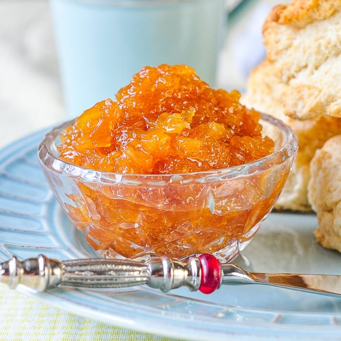 Photo of Roasted Pineapple Jam in a crystal serving dish with fresh biscuits in background