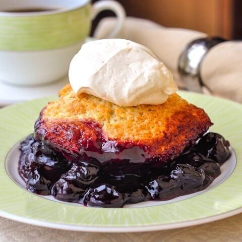 Photo of a single serving of cherry cobbler on a green and white plate