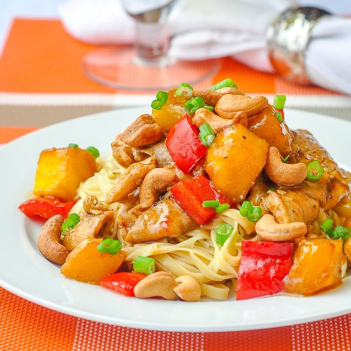 Spicy Mango Orange Pork with Cashews close up of a single serving on a white plate