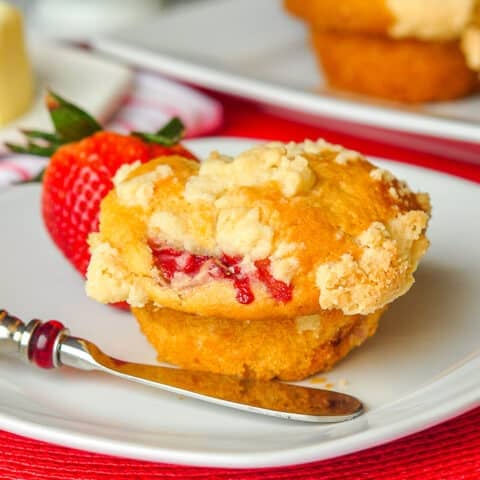 Strawberry Muffins with Shortbread Crumble close up photo of a single muffin on a white plate