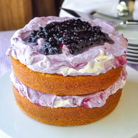 Blueberry Fool Butter Cake photo of uncut completed cake on a white cake plate