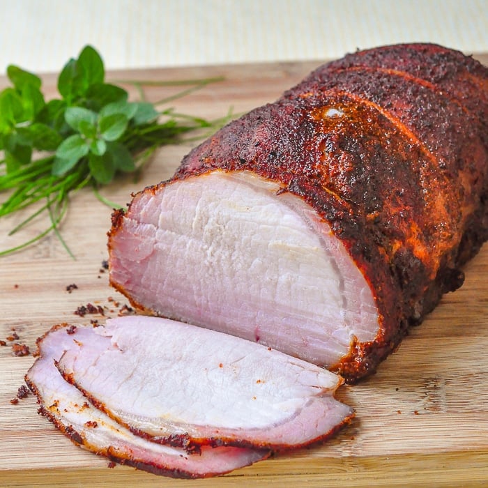 Smokin' Summer Spice Dry Rub on brined and smoked pork center loin roast shown on a wooden cutting board.