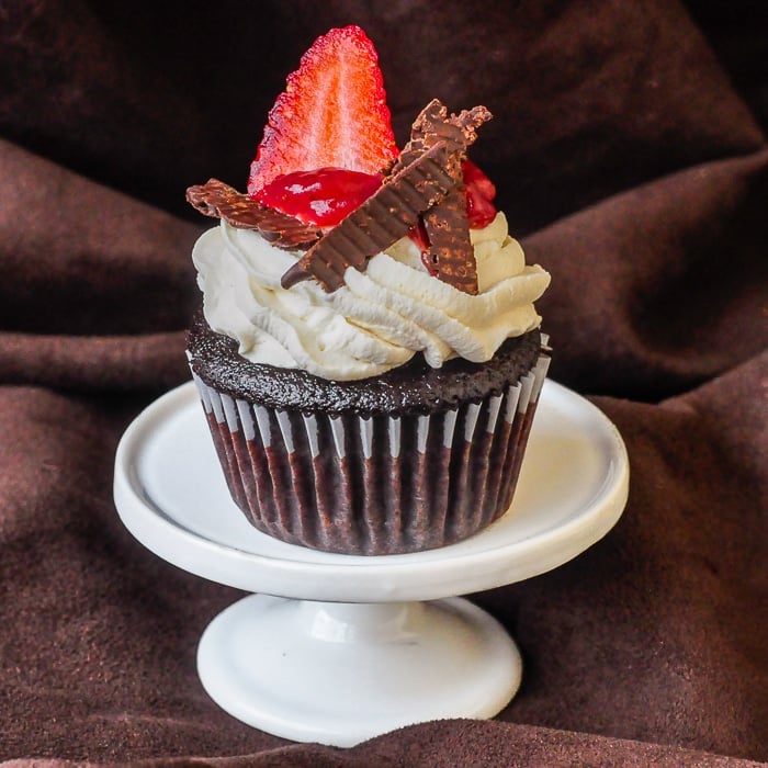 Strawberry Black Forest Cupcakes Photo of a single cupcake on a white cupcake pedestal