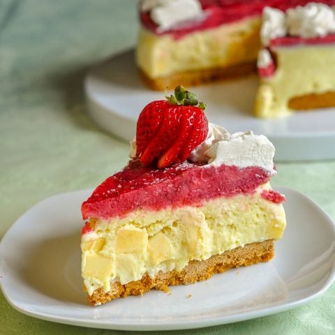 Strawberry Mango Ice Cream Pie vertical photo of single slice with pie in background.