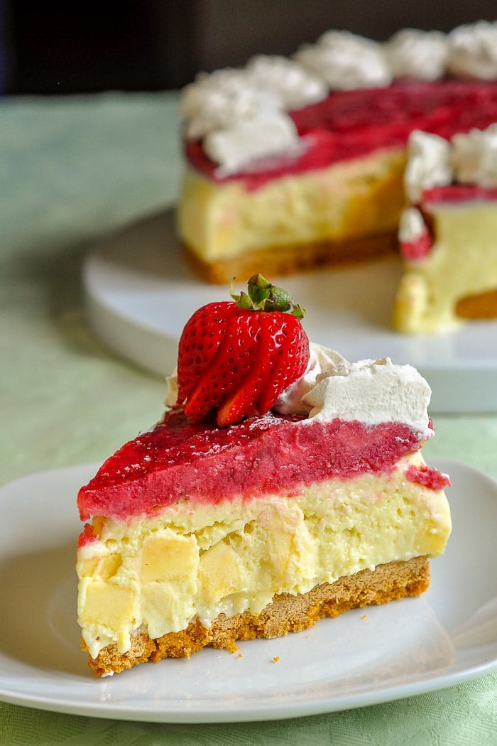 Strawberry Mango Ice Cream Pie vertical photo of single slice with pie in background.