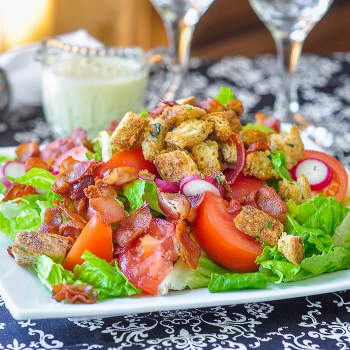 BLT Salad with Creamy Dijon Dressing and Garlic Herb Butter Croutons close up image of salad on white plate