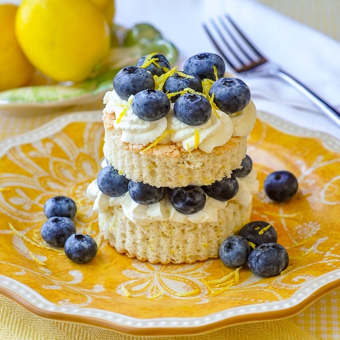 Lemon Berry Angel Food Shortcake featured square image, shown with blueberries on a yellow patterned serving plate.