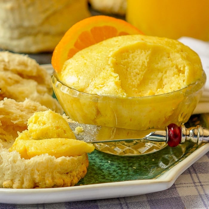 Maple Orange Butter close up photo of a pot of butter being spread on a biscuit