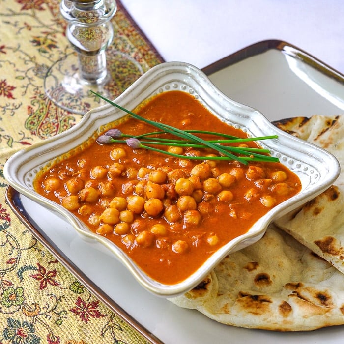 Easy Coconut Chick Pea Korma single serving in a white bowl with naan on the side