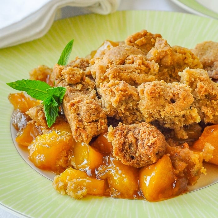 Mango Peach Coconut Crumble square cropped close up photo of a single serving on a green plate