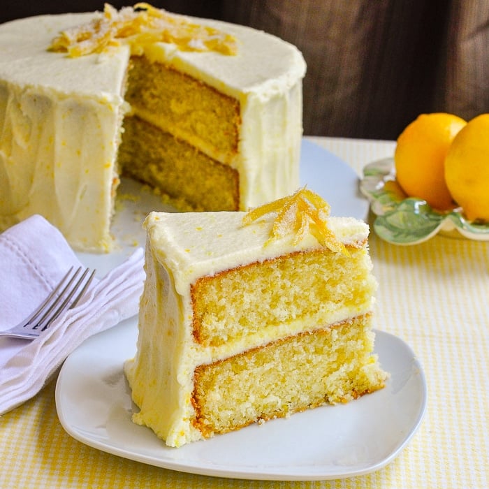 Lemon Velvet Cake wide shot of single slice with full cake in background