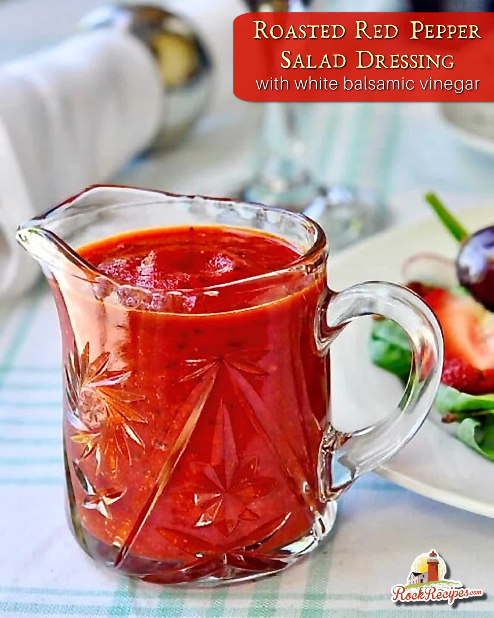 Roasted Red Pepper Salad Dressing. Photo of dressing in a clear glass Crystal jug with title text and rock recipes logo added for Pinterest and social media posts.