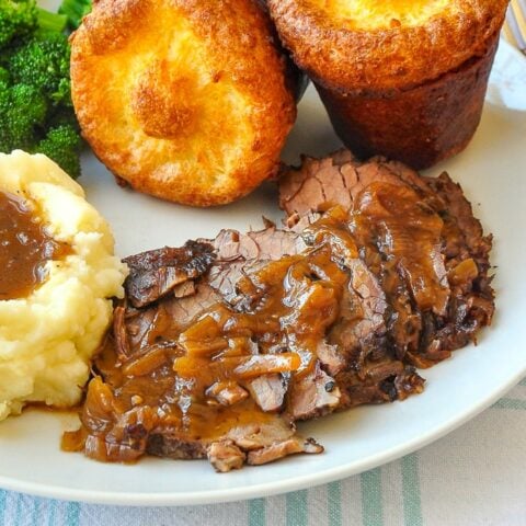 French Onion Braised Beef Brisket close up photo on white dinner plate