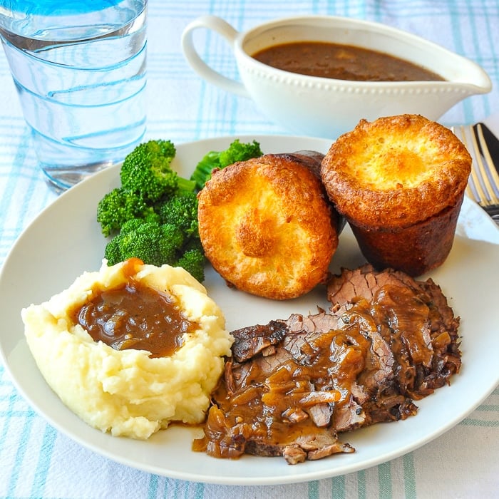 French Onion Braised Beef Brisket with mashed potatoes amd popovers on a white plate