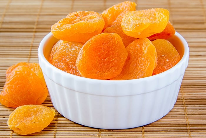 Dried apricots for Apricot Coconut Cookie Bars shown in white ramekin.