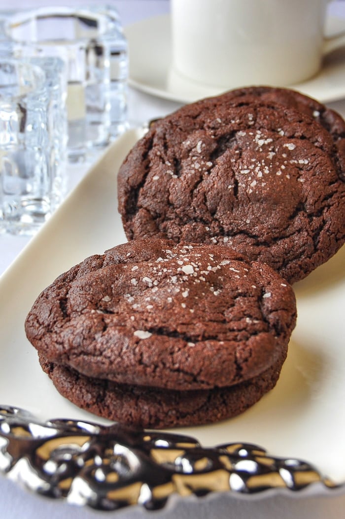 Caramel Stuffed Salted Chocolate Cookies on a white and silver serving platter