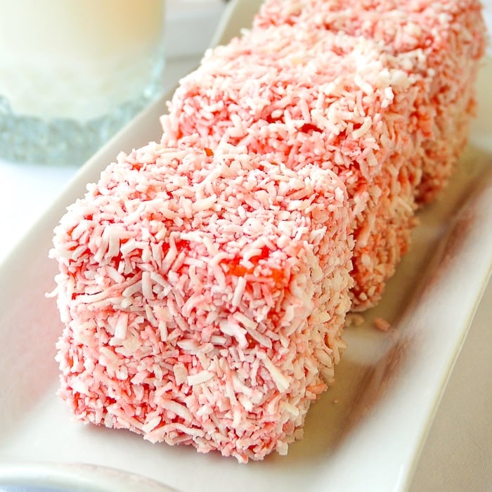 Strawberry Lamingtons with a glass of milk in the background
