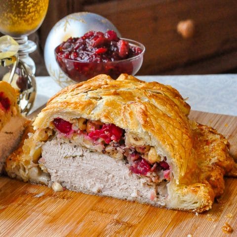 Cranberry Hazelnut Turkey Wellington close up photo of wellington cut open to reveal stuffing and turkey inside