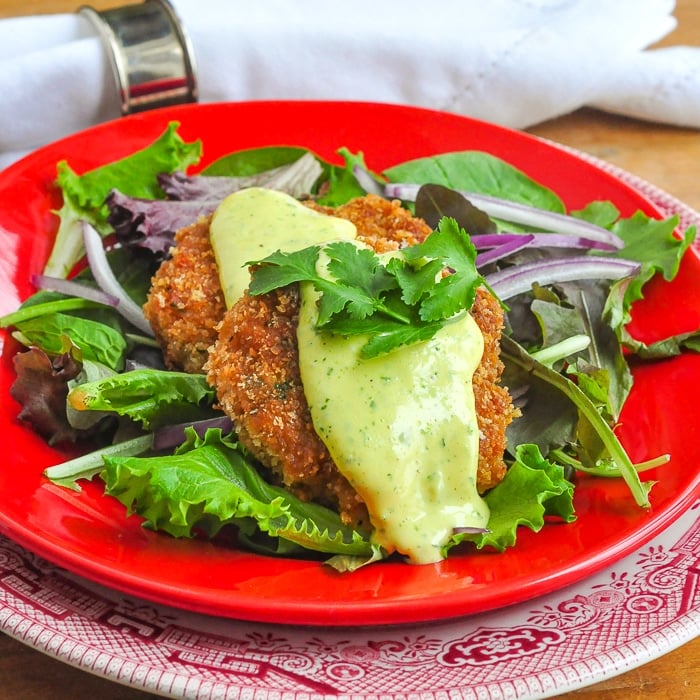 Shrimp Cakes with lime aioli photo ahown on a red plate with salad