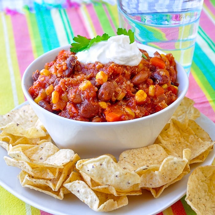 Quinoa Vegetarian Chili image of single serving with tortilla chips in a white bowl.