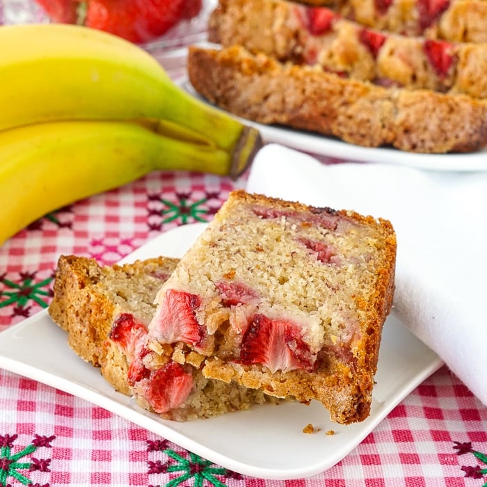 Strawberry Banana Bread close up photo of cut slice on a small white plate