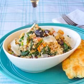 Spinach Parmesan Quinoa in a white bowl with biscuit on the side