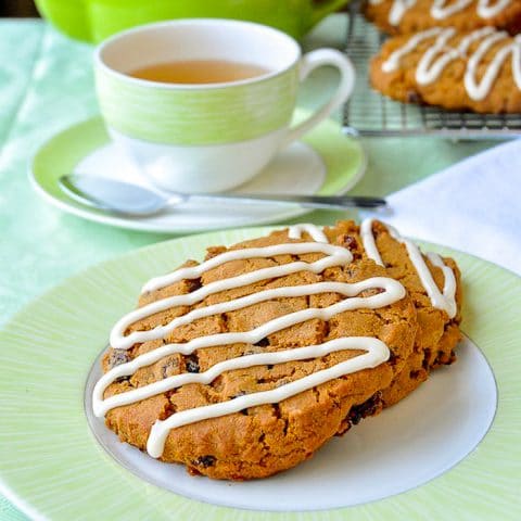 Molasses Raisin Biscuit Cookies shown on a green and white plate with tea in background
