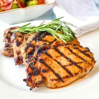 Rosemary Dijon Grilled Pork Chops close up photo on a white plate for featured image