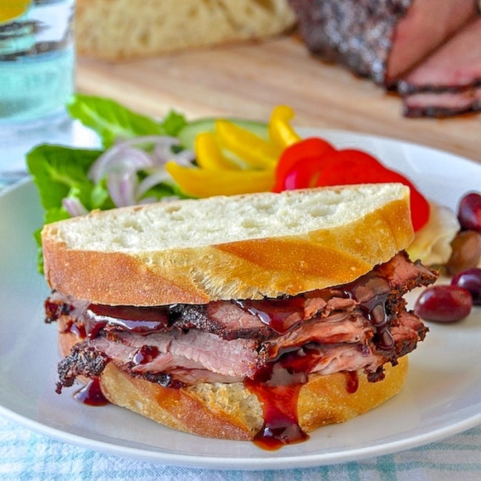 BBQ Beef Brisket Sandwich with barbecue sauce on a white plate