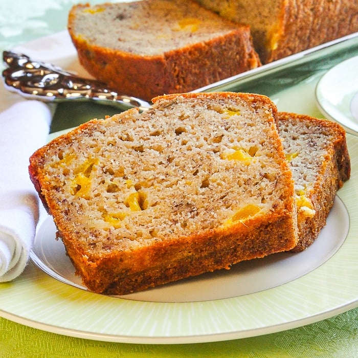 Close up photo of 2 slices of Mango Spice Banana Bread on a green plate