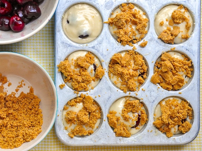 Adding the crumb topping to the cherry muffins