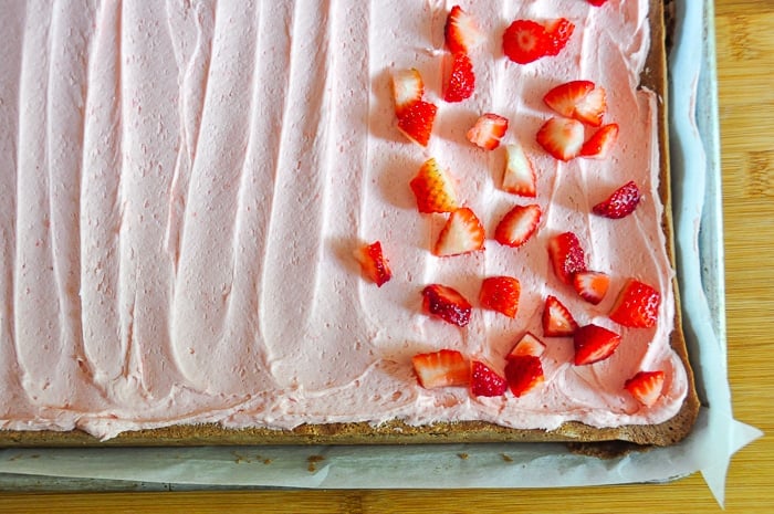Scatter strawberry pieces over the frosted cake