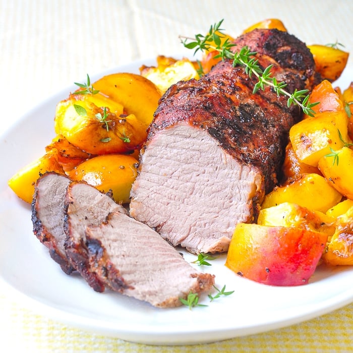 Grilled Balsamic Peach Pork Tenderloin shown sliced on a white serving platter