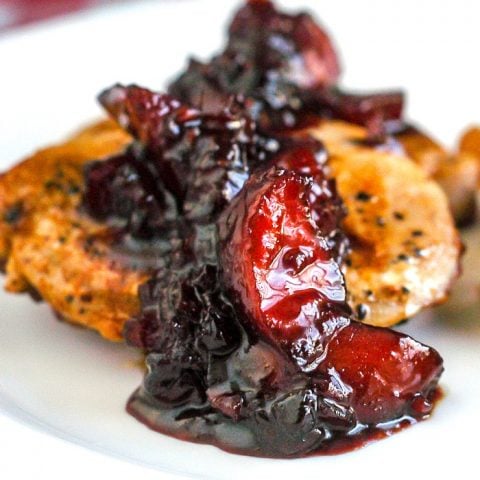 Blueberry Plum Chutney on Pan Seared Pork Chops close up photo on a white plate