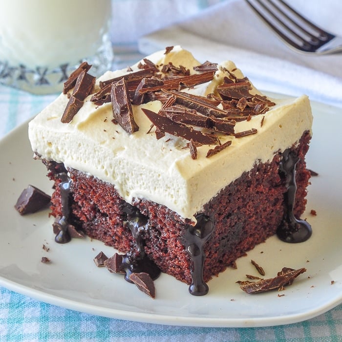 Chocolate Poke Cake close up photo of single serving on a white plate