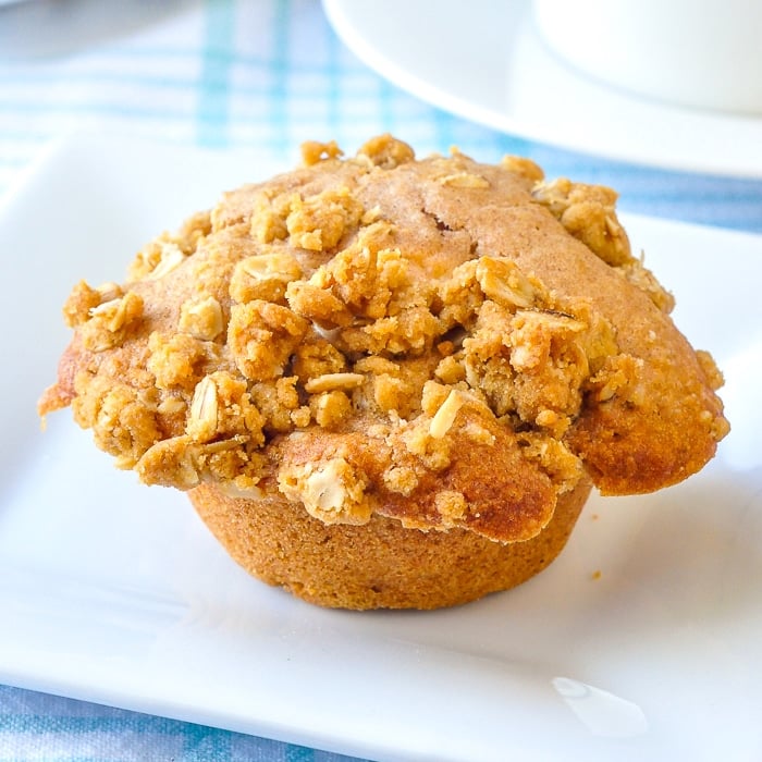 Apple Crumble Muffins close up photo of uncut muffin on a white plate