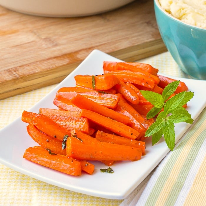Honey Roasted Carrots with mint on a white plate with fresh mint garnish
