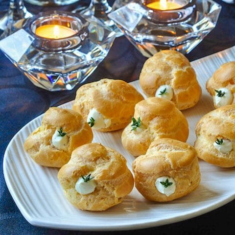 Garlic Thyme Cheese Puffs. close up shot on white serving plate.