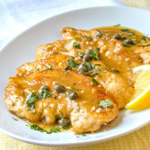 Lemon Chicken Piccata shown on white serving platter