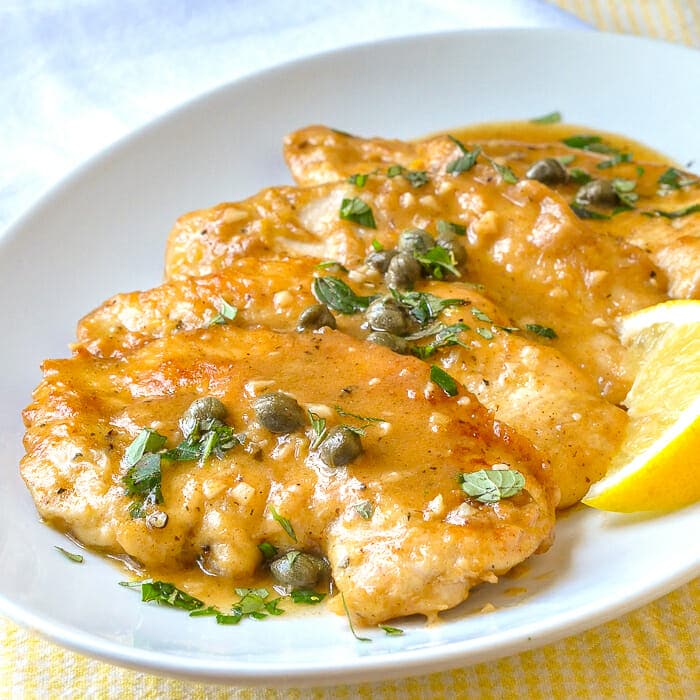 Lemon Chicken Piccata shown on white serving platter