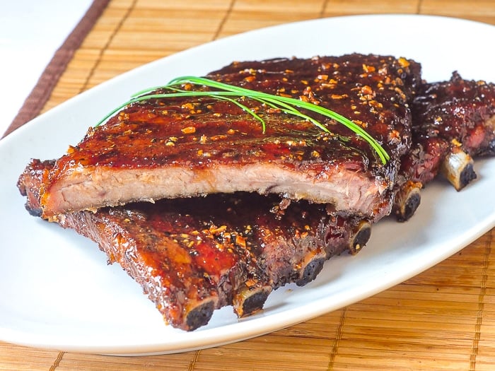 Honey Garlic Sticky Ribs photo of 2 half racks of ribs on a white platter