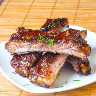 Honey Garlic Sticky Ribs stacked on a white plate