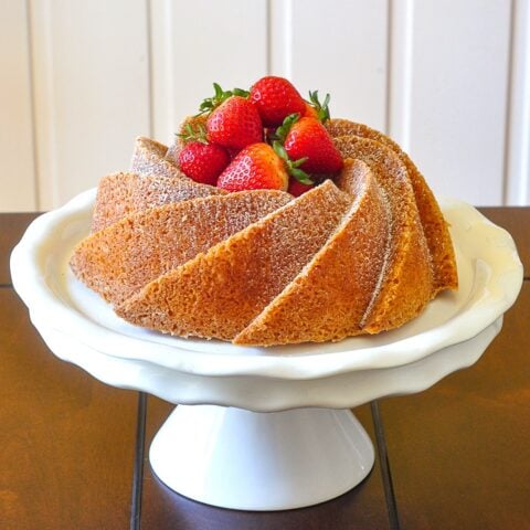 Orange Bundt Cake on a white pedestal stand