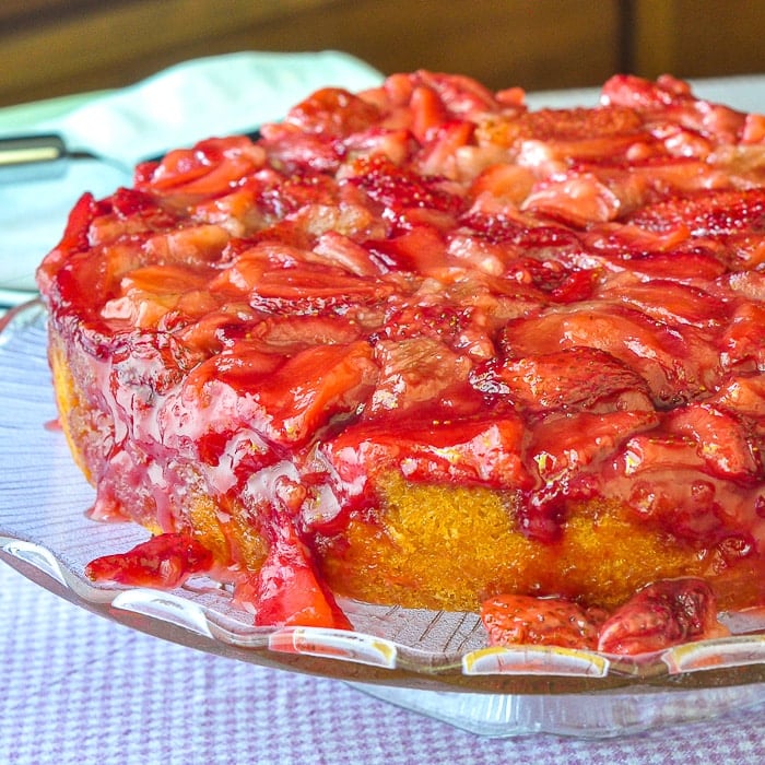 Strawberry Upside Down Cake photo of uncut cake on a clear glass cake pedestal