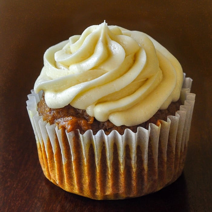 Sticky Toffee Pumpkin Cupcakes close up photo of a single cupcake on a dark wooden table