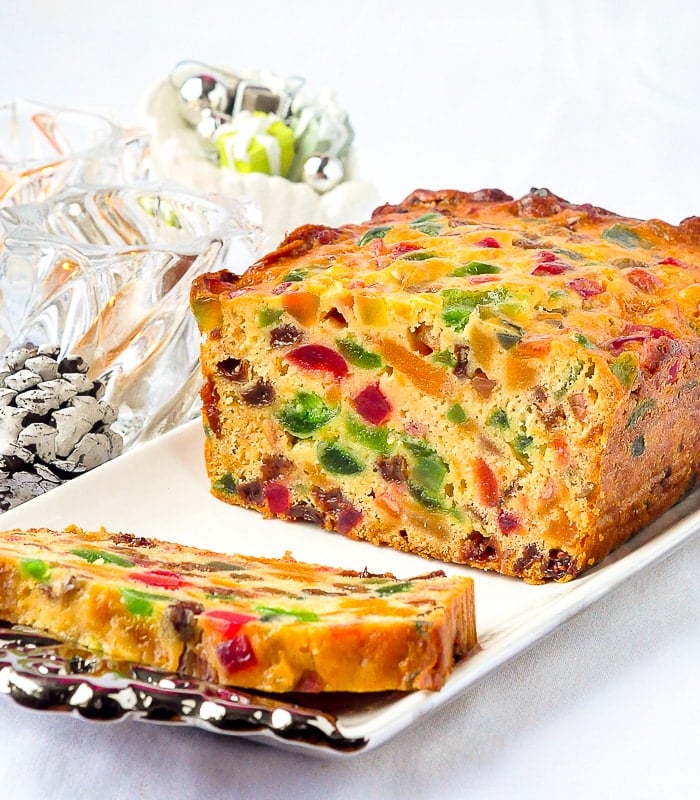 Apricot Fruitcake shown on a white background with candles in background