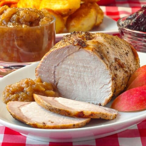 Maple Applesauce on Herb Roasted Pork Loin close up photo pf carved pork on a white platter
