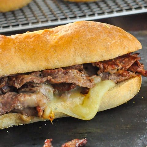 Homemade Philly Cheesesteak close up photo of completed sandwich on a slate platter